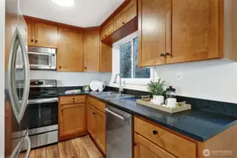 Black granite counters, solid wood cabinetry, and newly installed range, dishwasher and fridge - this kitchen is a delight!