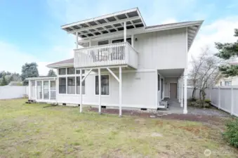 Backyard with access to garage, primary deck and sun room wiht sliding door