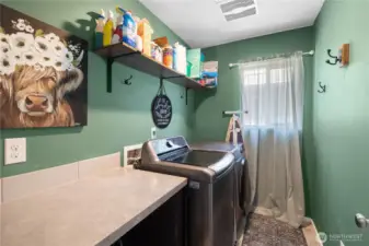 Laundry room on the same level as the bedrooms for convenience. Built-in counter with open storage below.