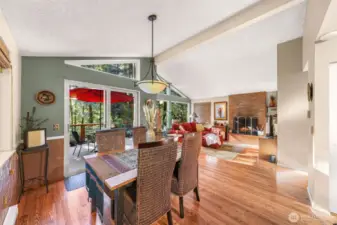 Dining area seamlessly flows from kitchen and into open living space, all with vaulted ceilings.