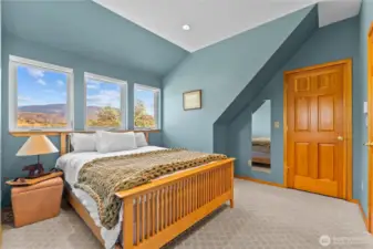 Upstairs bedroom with wood doors leading to closet.