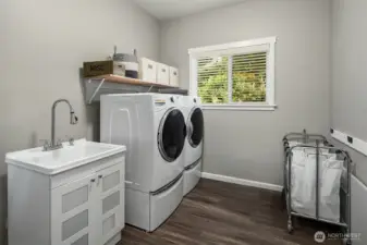 The laundry room offers thoughtful organization, modern appliances, and a window view that brings a touch of nature to everyday tasks.