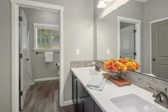 Beautifully designed for comfort and privacy, this full bathroom features dual sinks with a separate shower and tub area.