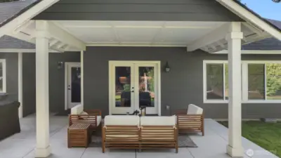 The covered patio offers year-round comfort — perfect for morning coffee, evening gatherings, or simply taking in the peaceful surroundings.