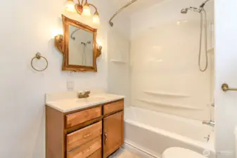 The bathroom features a bathtub and shower combo, offering both comfort and convenience.