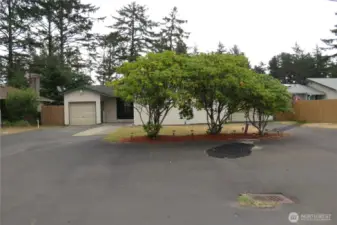 STREET VIEW OF THIS THREE BEDROOM TWO BATH HOME HAS PAVED PARKING UP FRONT AS WELL AS PAVED DRIVEWAYS TO EACH GARAGE!