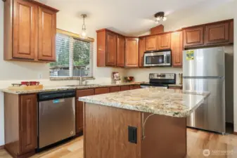 Luxury granite counters & warm, wood-grain cabinets
