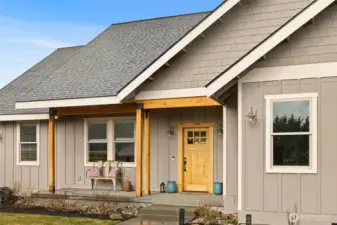 A covered front porch paired with a concrete deck/patio creates a welcoming entry and a comfortable outdoor space to relax and enjoy the surroundings.
