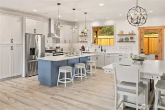 An exceptional lighting package enhances the open-concept kitchen and dining space, highlighting the finishes while creating a warm and inviting atmosphere throughout.