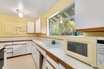 Large window above sink allowing views of the large side yard