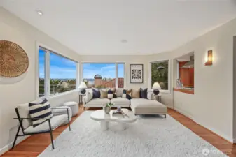 Another angle of the main floor living room with warm wood flooring and spacious layout.