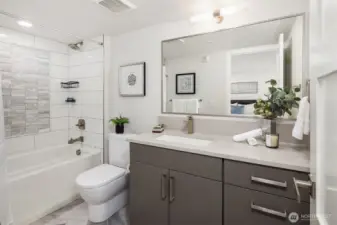 Ensuite bath features an oversized vanity and soaking tub with tile surround
