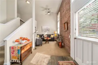 LIVING ROOM IS OFFSET BY ORIGINAL BRICK WALLS AND 16 FOOT CEILINGS