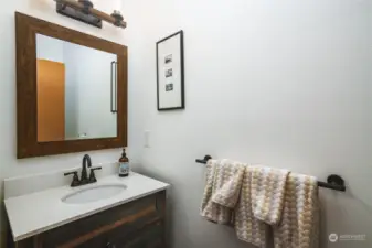 The main floor half bath has a barn-door vanity.