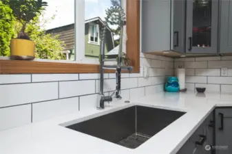 The gourmet kitchen comes complete with gorgeous quartz counter tops, a deep stainless sink an top notch faucet. Notice the under cabinet lighting as well!