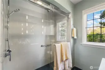 Tile shower with Grohe fixture (new in 2022), grab bars. Glass doors by Seattle Shower Door with ShowerGuard finish.