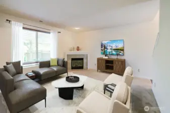 Living room overlooks the backyard and features corner gas fireplace. Photo virtually staged.