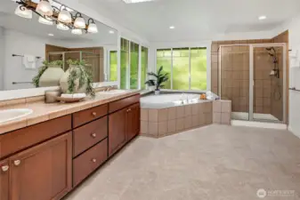 The spa-inspired primary bathroom offers a luxurious escape with its oversized soaking tub framed by large privacy windows that bathe the space in natural light.