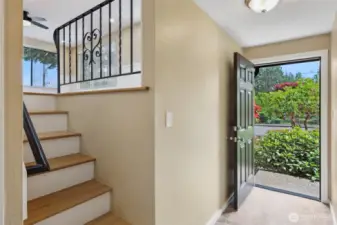 This shows front door entrance. stairs lead to living, dinning and kitchen. to the right is a hallway to bedrooms and to left goes down a few steps to lower level