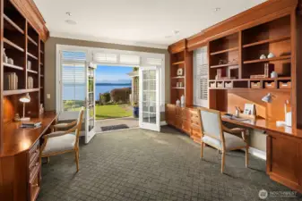 Looking west through the Den/Library with custom built-ins through the French doors to beyond.