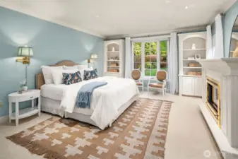 Tranquil Primary Suite with gas fireplace looking to front garden.