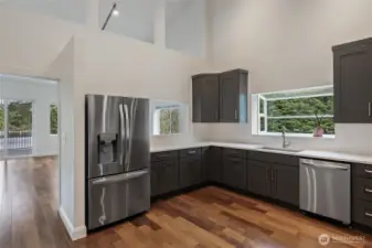 Newly remodeled, large kitchen with quartz countertops, new LG ThinQ appliances, soft-close cabinet drawers, double sink with garden window, kitchen pass-through window to Great Room / Living Room / Dining Room.