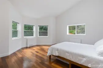 Second Bedroom on main level - extra spacious, vaulted ceiling, skylight, east-facing windows, new window blinds, radiator heating.