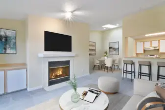 Bright and open living room with cozy wood-burning fireplace, dining room and kitchen!