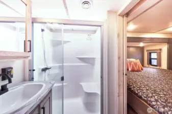 Bathroom has large walk-in shower with a bright skylight.
