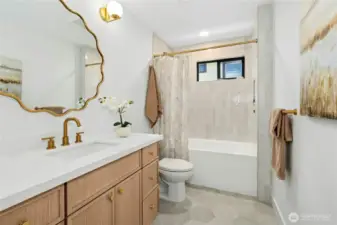 Hall bath on the main level - check out the designer mirror, really pretty floor and bath surround tile and of course, quartz counters...