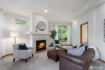 The living room is anchored by a gas fire place and tons of windows that look over the greenspace.