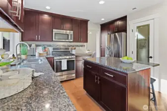 Kitchen with granite countertops, island seating, and walk-in pantry