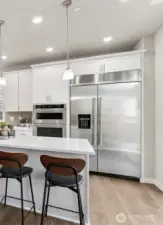 Showing the included built in refrigerator with water & ice feature. White cabinets are an option available to add early in the process.