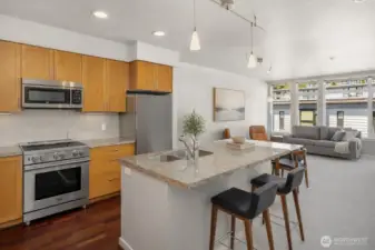 Fresh paint, granite counters, and warm wood cabinetry enhance the kitchen’s clean, timeless appeal. Note: This image has some AI generated staging.