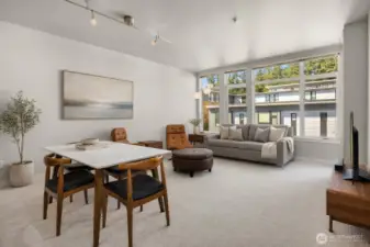 Large windows bring in beautiful natural light and enhance the home’s airy feel. Note: This image has some AI generated staging.