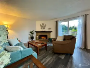 Living room with brick-wood fireplace and slider to the back deck and the view!