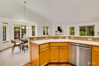 The openness of this kitchen, the vaulted ceiling, and the many windows really welcome the light into this warm and inviting home.