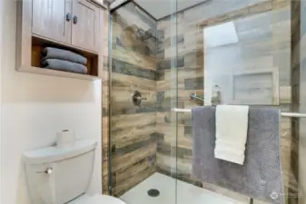 This spacious walk in shower with glass door is a stunning update! Notice how the tile goes all the way to the ceiling and the added touch of a built-in niche for all of your shower needs.