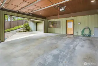 Spacious Car Storage: Semi-enclosed two-car carport with a garage door, plus an additional third garage.