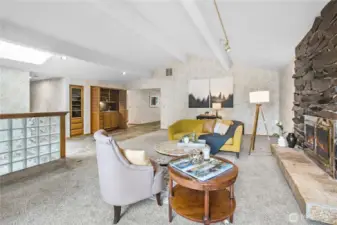 Elegant Living Room with Cathedral Ceiling: Featuring soaring vaulted ceilings that amplify the sense of space and light, anchored by a stunning basalt rock fireplace that adds natural warmth and rustic charm to the heart of the home.