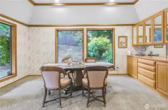 Elegant Formal Dining Room: A sophisticated space overlooking meticulously manicured landscaping, featuring a built-in china cabinet and additional lower storage cabinets—perfect for displaying treasured dinnerware and keeping essentials close at hand during gatherings.