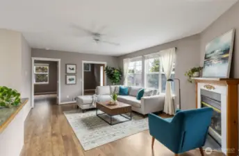 Virtually staged living room. Room for two easy chairs in front of the propane fireplace in addition to a sofa and coffee table along with chairs along the far wall. Nice & open so you can visit with folks in the kitchen; great for entertaining.