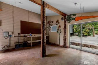 A cheerful nook for potting, painting, or tinkering—this light-filled workshop brings the outdoors in with playful murals, rustic beams, and easy access to the garden just beyond the sliding door.