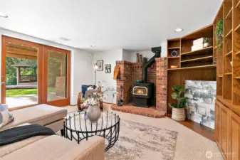 Basement rec room with cozy wood stove and built in cabinetry