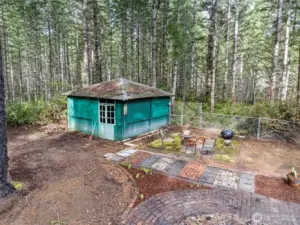 Outbuilding, firepit and brick walkways remain