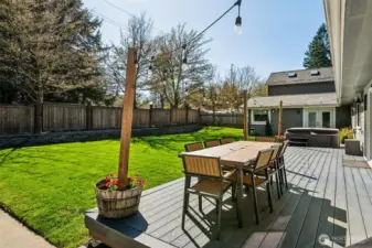 Right off the dining room slider, a generously sized composite deck gives you plenty of room to spread out with dining, lounging, or a full outdoor setup that doesn’t feel cramped. The composite material keeps things looking sharp with minimal upkeep, which means more time enjoying it and less time maintaining it. Just beyond, the hot tub is already in place and stays with the home, ready for evening unwinds or weekend resets. The yard itself is level, lush, and faces south, so it gets great sun throughout the day, perfect for lawn games, future garden beds, or just soaking up the light.