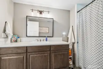 This main bathroom keeps things practical with just the right amount of space to make mornings run smoother. The tile flooring is a smart choice for durability and easy cleanup, while the tub and shower combo keeps it versatile for everyday use. The vanity offers a generous stretch of counter space, which is one of those underrated features that makes sharing a bathroom feel a lot less crowded.