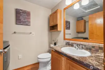 Main-level powder bath combined w/ utility space—smart layout offering function & convenience in one central spot.