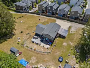 Aerial view showcases the full scale of the backyard & home—highlighting outdoor living space, layout, & surrounding privacy.