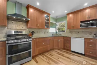 Updated kitchen w/cherry wood cabinetry, granite countertops, hickory flooring, and stainless appliances. View of the ADU and side yard/patio.